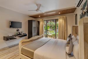 a bedroom with a large bed and a tv at Skon Morjim Beach Resort by Orion Hotels in Morjim