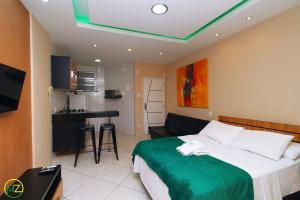 Un dormitorio con una cama grande y una cocina. en Studio com pequena varanda em Copacabana, en Río de Janeiro