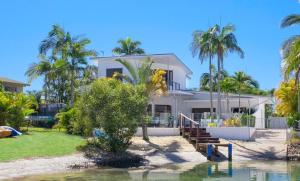 a house on the beach with palm trees at 14 Cooran Court in Noosa Heads