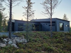 a modern house in the woods with trees at Villa Kanger Ruka 2 in Kuusamo