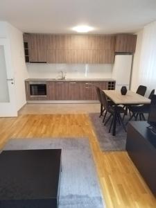 a kitchen and dining room with a table and chairs at Apartman Ranka in Lukavica