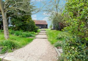 un chemin menant à une maison dans un jardin dans l'établissement Pound Hill Cottage, à Frittenden