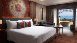 a bedroom with a large bed and a living room at Amari Vogue Krabi in Tab Kaek Beach