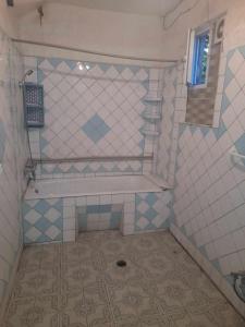 uma casa de banho com banheira e piso em azulejo em individual low-budget guest-house em Tsqaltubo