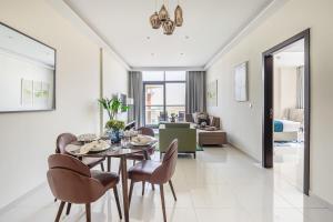 a dining room with a table and chairs and a living room at Frank Porter - Damac Celestia in Dubai