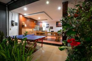 a dining room with a table and some plants at Asri Guesthouse in Canggu