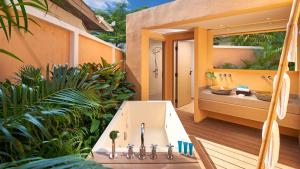 a bathroom with a tub and a sink on a deck at Amari Vogue Krabi in Tab Kaek Beach