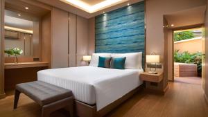 a bedroom with a large bed with a blue painting on the wall at Amari Vogue Krabi in Tab Kaek Beach
