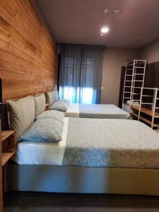 a bedroom with two beds and a wooden wall at Dannunziano Aparthotel in Chieti