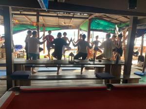 a group of people standing around a table doing yoga at Beach House Cambodia in Koh Rong Sanloem
