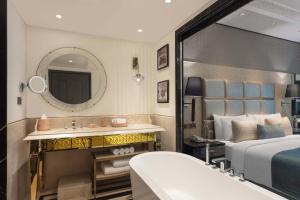 a bedroom with a bed and a sink and a mirror at ITC Narmada, a Luxury Collection Hotel, Ahmedabad in Ahmedabad