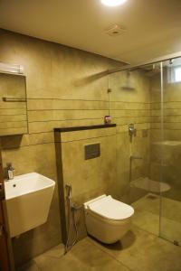 a bathroom with a toilet and a shower and a sink at Mezkar Residency in Alwaye