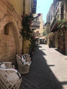 an alley with wicker chairs on the side of a building at Lito Rooms in Chania