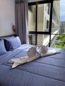 ein herzförmiges Handtuch auf einem Bett mit Fenster in der Unterkunft Marvest Condo Hua Hin for rent in Hua Hin