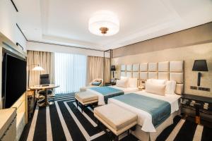 a hotel room with two beds and a flat screen tv at ITC Narmada, a Luxury Collection Hotel, Ahmedabad in Ahmedabad