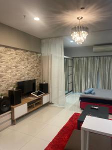 a living room with a bed and a television at Mercu Summer Suite KLCC Studio with Karaoke in Kuala Lumpur