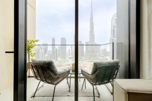 uma varanda com 2 cadeiras e uma mesa com vista em Luxury 2BR High floor Apt. w/ Burj Khalifa view with laser light show and Dancing Fountain View em Dubai