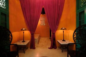 a room with red curtains and two tables and chairs at Casa Heliconia in Gampaha