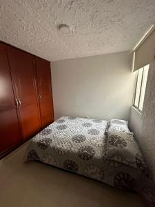 a bedroom with a bed and a dresser at Apartamento cómodo con excelente ubicación in Bucaramanga