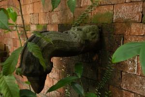 a gargoyle on the side of a brick wall at Casa Heliconia in Gampaha