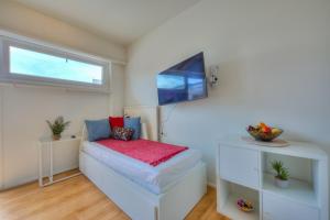 a bedroom with a bed and a flat screen tv at Cosy Home Lugano Few Min From Lake - Happy Rentals in Lugano