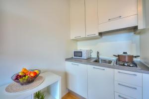 a kitchen with a bowl of fruit on a table at Cosy Home Lugano Few Min From Lake - Happy Rentals in Lugano