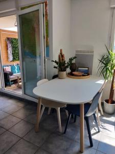 een witte tafel en stoelen in een kamer bij Charmant appartement avec magnifique vue in Monnetier-Mornex