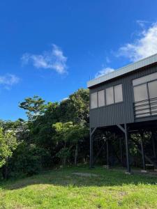 蒙特韋爾德哥斯達黎加的住宿－Calma, Monteverde - Expect Serenity Here，一座位于郁郁葱葱的绿色田野顶部的建筑