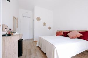 ein Schlafzimmer mit einem weißen Bett mit roten Kissen darauf in der Unterkunft PRIMO RENT ROOM in Mesagne