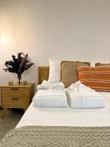 蒙特韋爾德哥斯達黎加的住宿－Calma, Monteverde - Expect Serenity Here，一张带两个白色枕头的床和木制床头柜