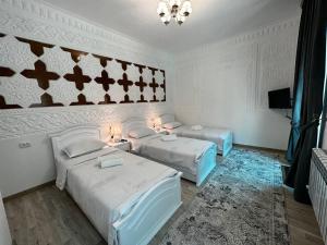 a room with two beds and a chandelier at OLD STREET Guest House in Samarkand