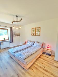 1 dormitorio con 1 cama grande y suelo de madera en Appartments am Waldbad - Unterm Nussbaum, 