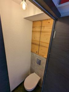 ein kleines Bad mit WC und Holzschränken in der Unterkunft Ecrin Alpe d'huez in Huez