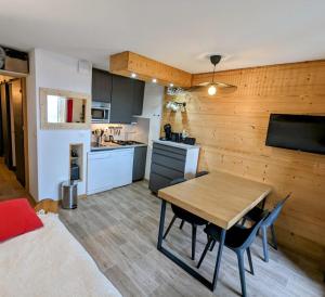Zimmer mit einem Bett und einem Tisch sowie einer Küche in der Unterkunft Ecrin Alpe d'huez in Huez