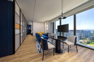 a living room with a blue couch and a table with chairs at Aloft Yantai in Yantai