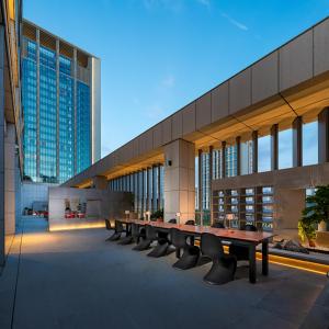 a long table and benches in front of a building at Aloft Yantai in Yantai