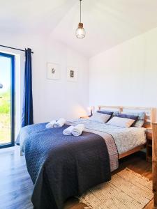 a bedroom with a bed with two towels on it at VIEW of SMEREK- domki z klimatyzacją in Smerek