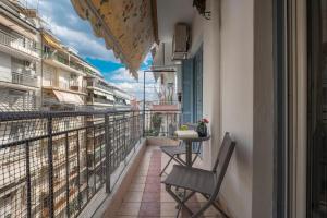 balcone con 2 sedie e un tavolo sopra di Estia Thessaloniki Apartment, cozy, spacious, sunny, 2 rooms-5 beds a Salonicco