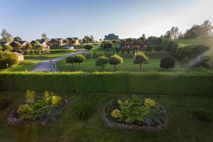 vista su un giardino con fiori e cespugli di PANORAMA Domki i Pokoje Nad Jeziorem 660-332-576 a Polańczyk
