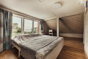 a bedroom with a large bed and a large window at Beach Home for Nature Lovers in Bernāti