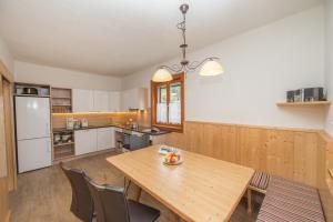 a kitchen with a wooden table and chairs at Ferienhaus Gerlinde I + II in Kaprun