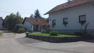 une maison avec un mur en pierre à côté d'une allée. dans l'établissement Guest House Family Dukić, à Rakovica