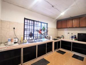 a kitchen with a counter with a sink and a window at Ventura Hotel and Tours in Gua Musang