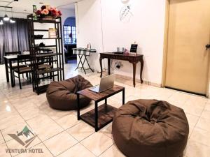 a room with two bean bags and a laptop on a table at Ventura Hotel and Tours in Gua Musang