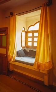 齋沙默爾的住宿－The Elite Castle，一张带黄色窗帘的床