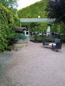 un patio con sillas, una mesa y un banco en Hôtel Restaurant Bar du Commerce - KB HOTEL GROUP en Tronget