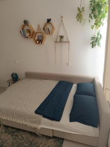 a bed in a room with plants on the wall at Cozy one-room apartment with garage and AC in Bratislava
