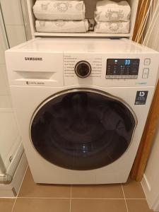a white washing machine in a kitchen with towels at Cozy one-room apartment with garage and AC in Bratislava