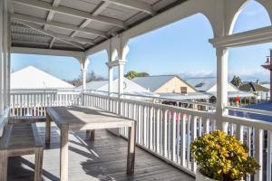 a porch with a wooden table and a bench at Altitude Apartment, Martinborough in Martinborough 