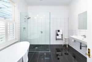 a white bathroom with a tub and a sink at Altitude Studio Apartment in Martinborough 